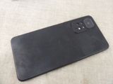 the back of a black cell phone sitting on top of a table