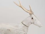 a white wooden deer with antlers on it ' s head