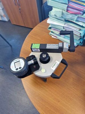 un appareil photo posé sur une table, avec une pile de papiers en arrière-plan