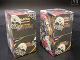 two boxes of pokemon trading cards sitting on a table