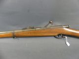 an old rifle with a wooden handle on a gray background