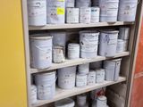 many buckets of paint on the shelves in the room
