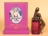 a bottle of perfume sitting next to a statue of a woman