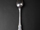 a close up of a silver spoon on a black surface