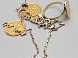 two gold rings and a chain with a coin on it