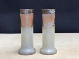 two vases sitting on a table with a black background
