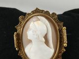 un gros plan d'une bague sur laquelle est gravé le profil d'une femme