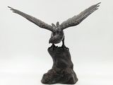statue of a bird perched on a tree stump on a white background