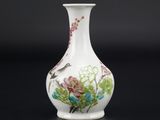 un vase blanc avec des fleurs et des oiseaux peints dessus