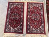 deux tapis rouges à franges posés sur le sol