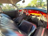 une voiture rouge avec des sièges en cuir noir à l'arrière