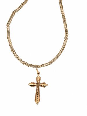 un collier en or avec un pendentif en forme de croix au bout d'une chaîne