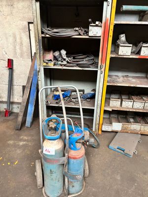 un chariot contenant des bidons d'essence et d'autres outils dans un garage