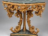 une table richement sculptée, dotée d'un plateau en marbre et ornée de décorations à la feuille d'or