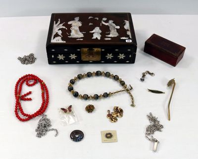 une boîte en bois sur laquelle sont disposés plusieurs bijoux