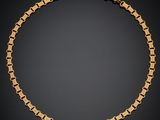 un bracelet en chaîne dorée à maillons carrés sur fond noir