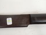 a large knife with a sticker on it sitting on a table