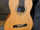 an acoustic guitar sitting on the floor next to a guitar case