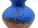a blue vase that is sitting on a white surface