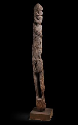 une statue représentant un homme debout sur un bloc de bois