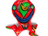 une figurine représentant une grenouille rouge au visage vert