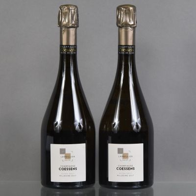 two bottles of wine sitting on top of a table next to each other