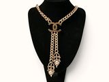 a black mannequin with a gold chain and a necklace on it