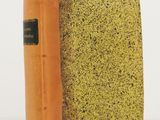 un livre à la couverture jaune posé sur une surface blanche