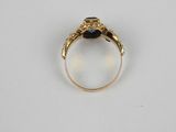 a gold ring with a blue stone in the center