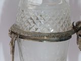 a glass vase with a bird on it on a table