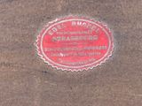 a red plaque on the sidewalk of a building