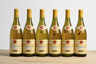 six bottles of wine are lined up on a wooden table