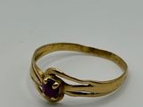 a close up of a gold ring with a purple stone
