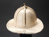 a white fireman ' s helmet on a black stand
