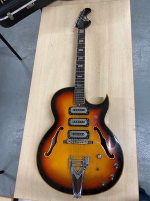 une guitare posée sur une table en bois