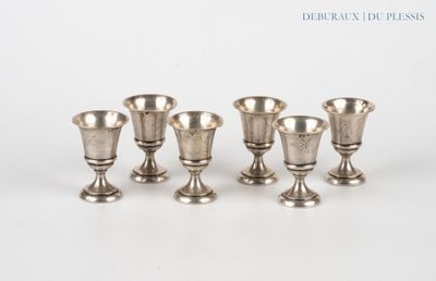 four silver vases sitting next to each other on a white surface