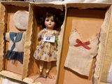 a doll in a box with clothes on it