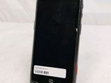 a black cell phone sitting on a stand on a table