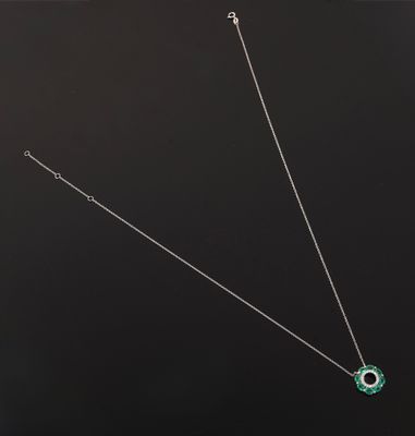 un gros plan d'un collier orné d'une fleur verte