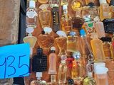 many bottles of perfume on a table with a price tag
