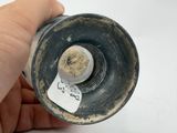 a hand holding a small metal object with a tag on it