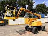 a yellow crane that is sitting in the middle of a parking lot
