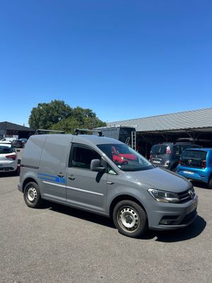 La camionnette grise est garée sur un parking avec d'autres voitures.