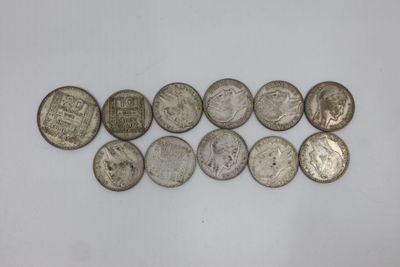 a bunch of silver coins sitting on top of a white surface