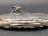 a silver purse that is sitting on a table