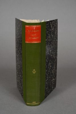 an old book with a green cover sitting on top of a table