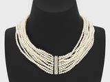 un gros plan d'un collier de perles blanches sur un mannequin