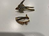 deux paires de boucles d'oreilles posées sur une surface blanche