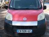 une petite voiture rouge et noire garée sur un parking