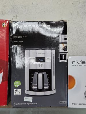 two boxes of coffee machines on a shelf next to each other